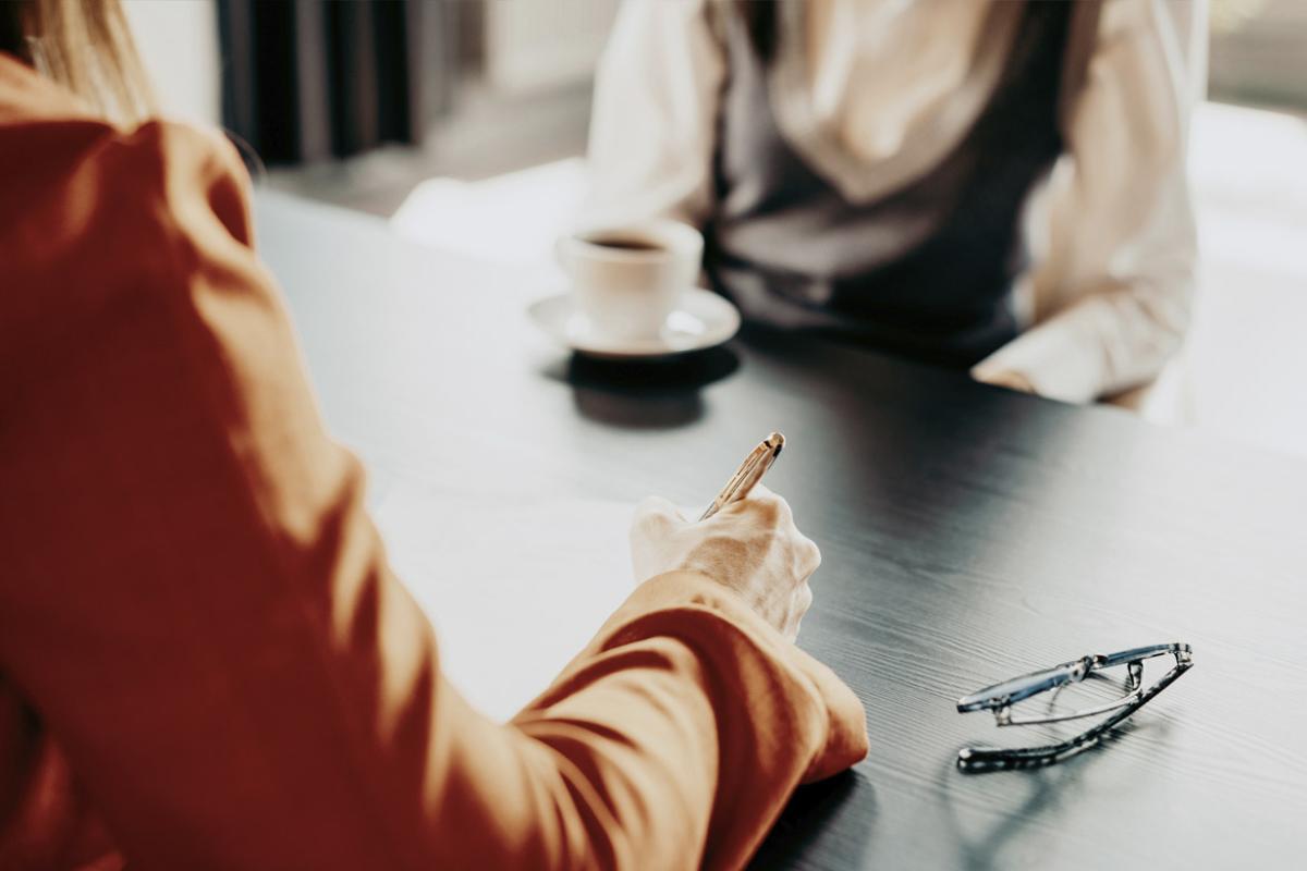 Two professionals conducting a business meeting over coffee at the office desk 