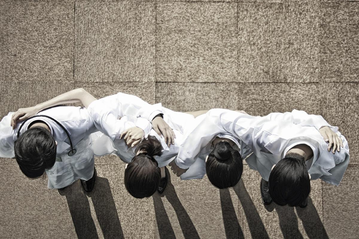 Row of doctors put arms around each other
