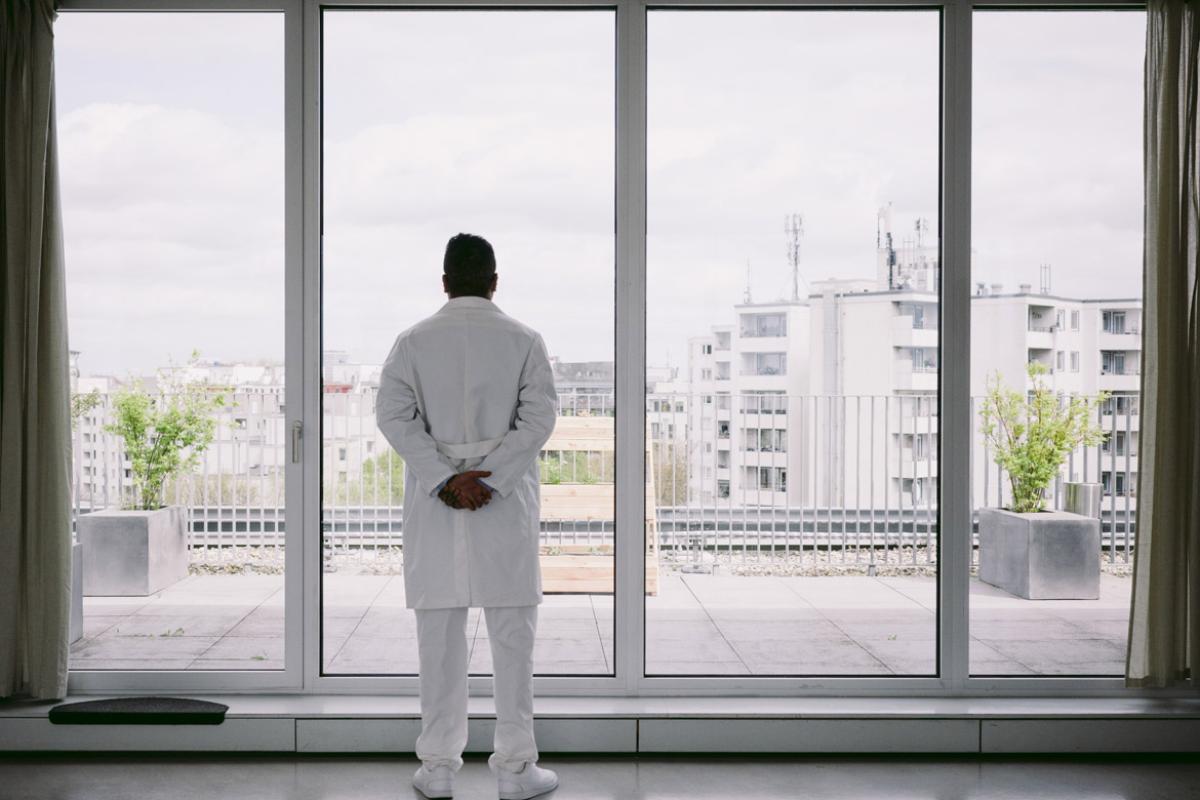 Physician stands in front of a window
