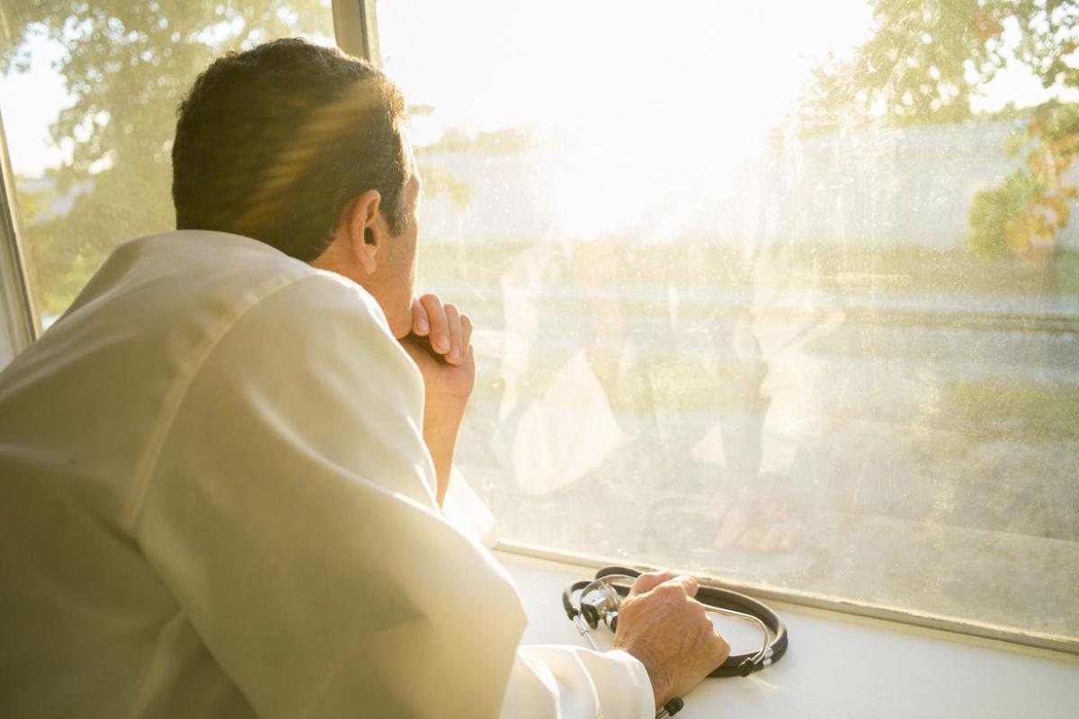 Physician looks out a window