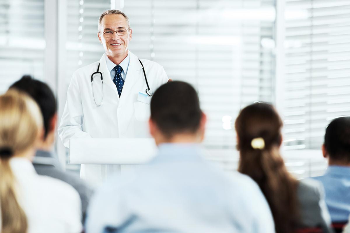 A medical educator instructs a classroom of medical students.