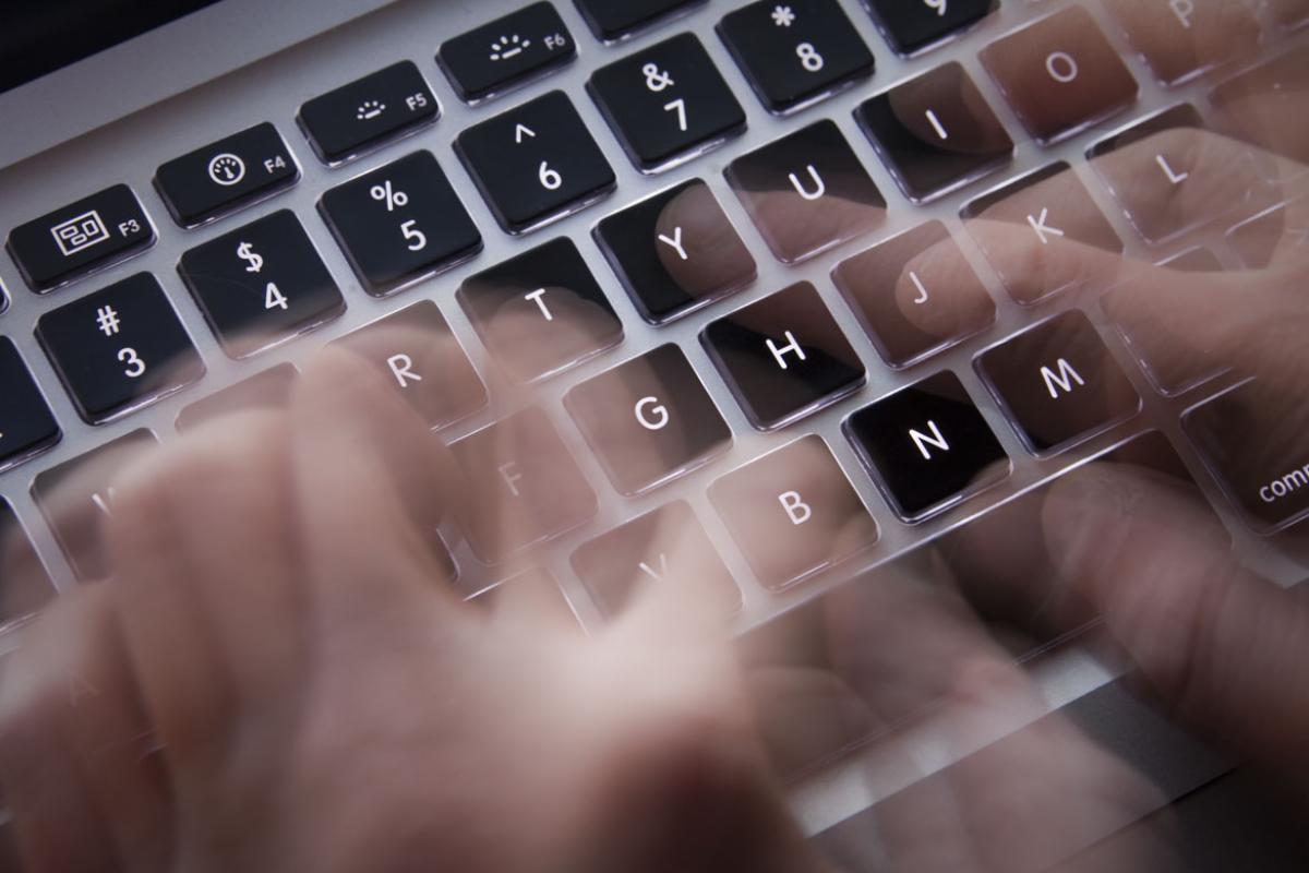 Fingers racing across the keyboard of a computer