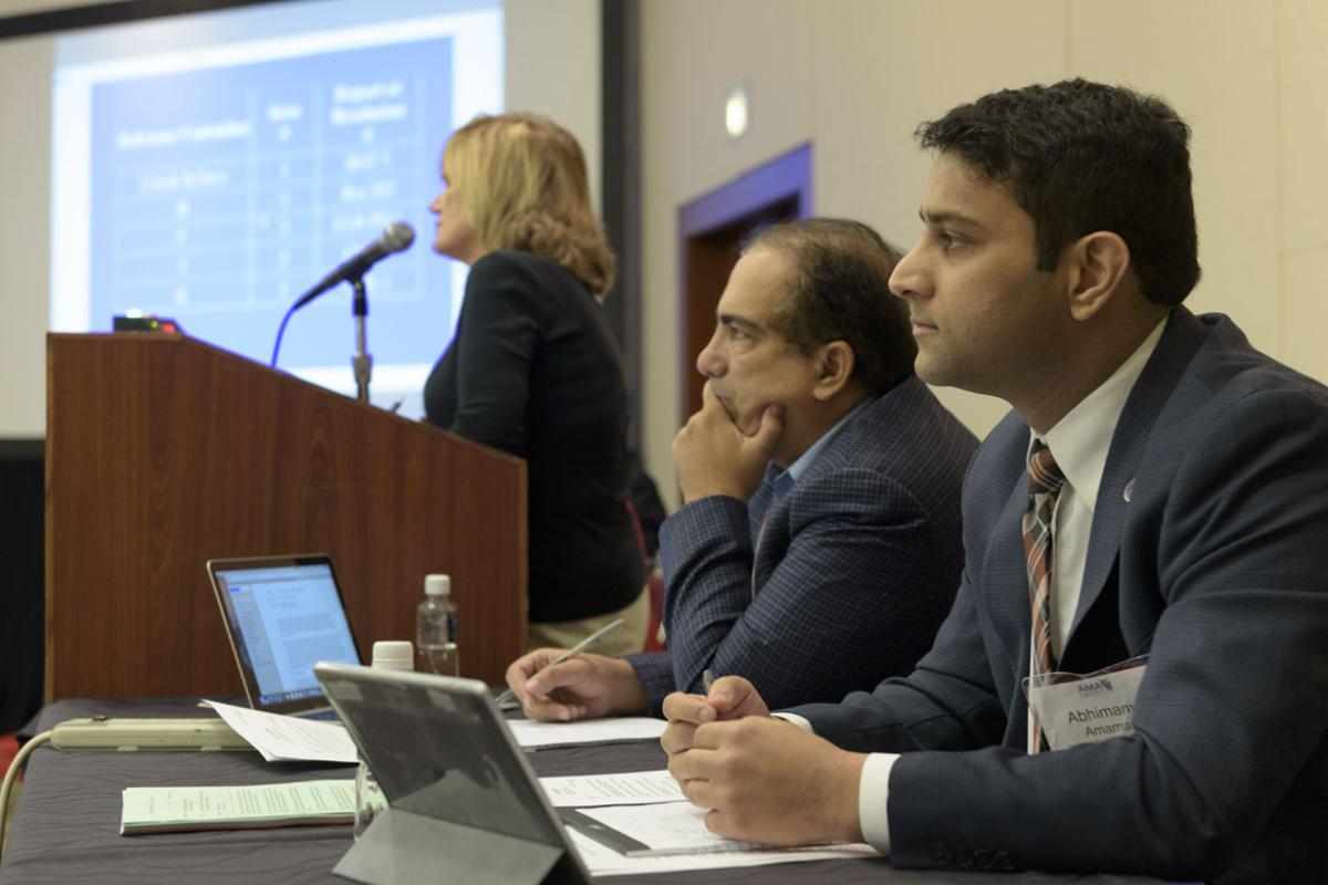 Physicians on panel listen to speaker.