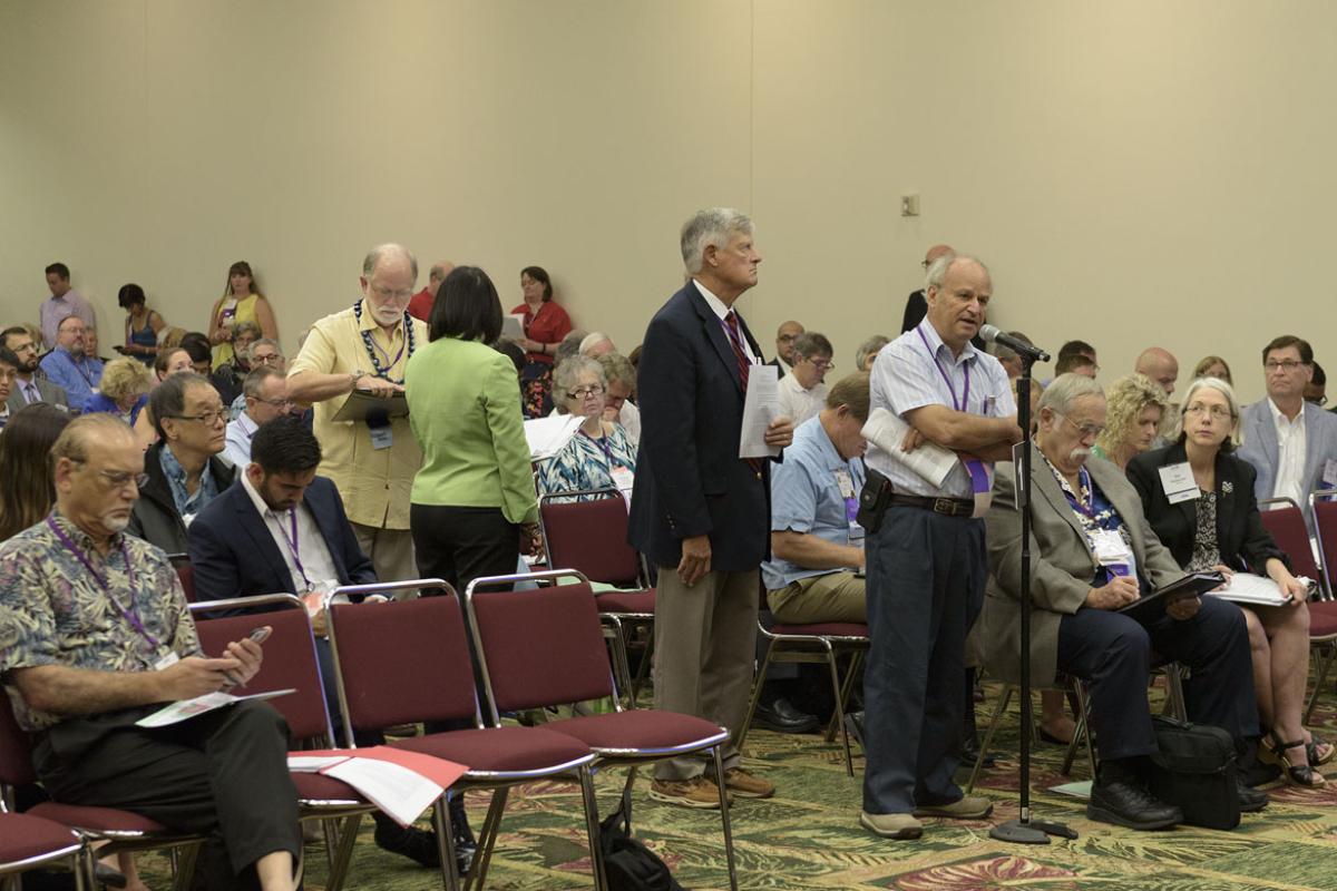 Commentors standing in line at microphone to make a remark.