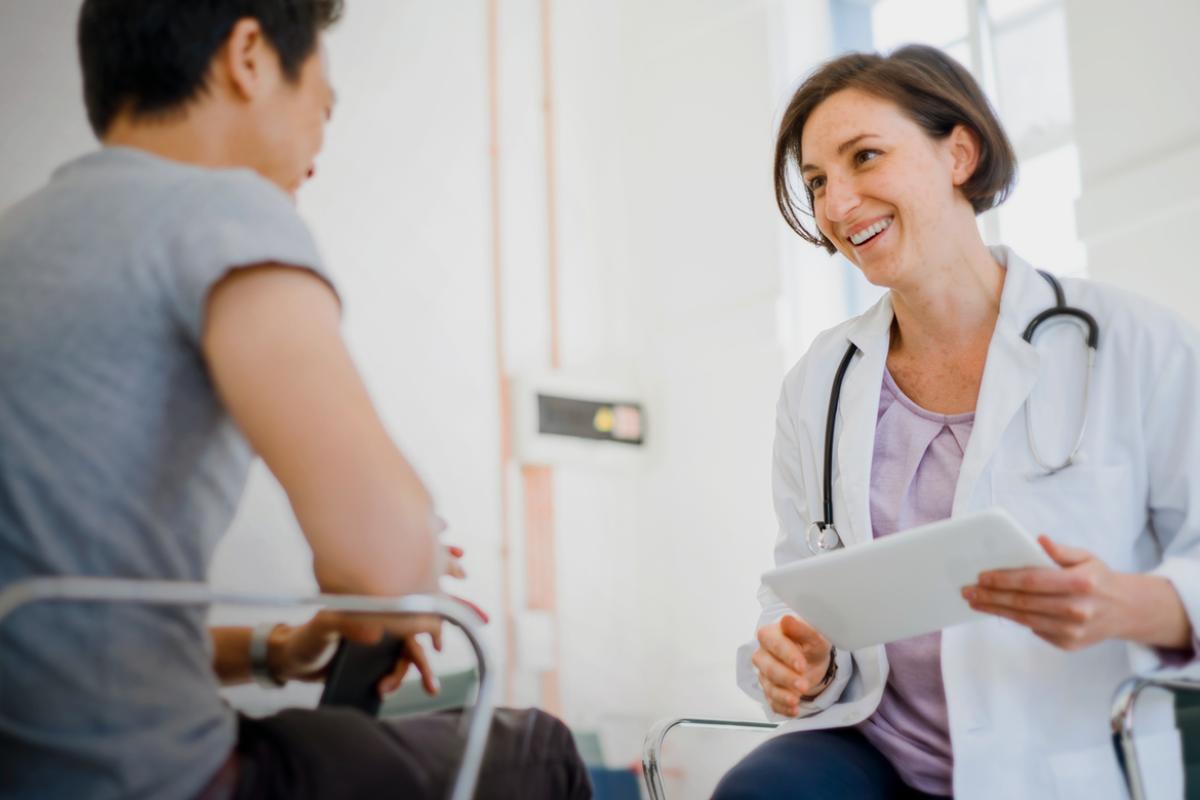 Smiling physician shares data with patient.