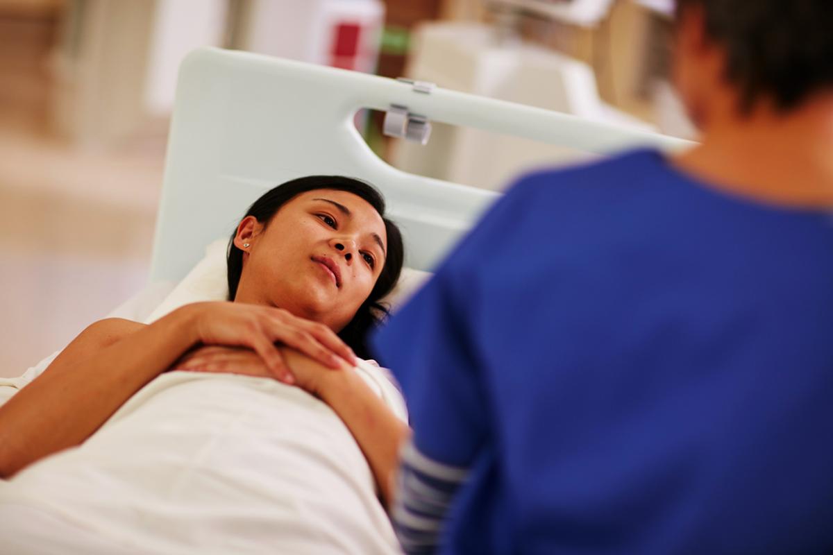 Physician speaks to patient in bed.
