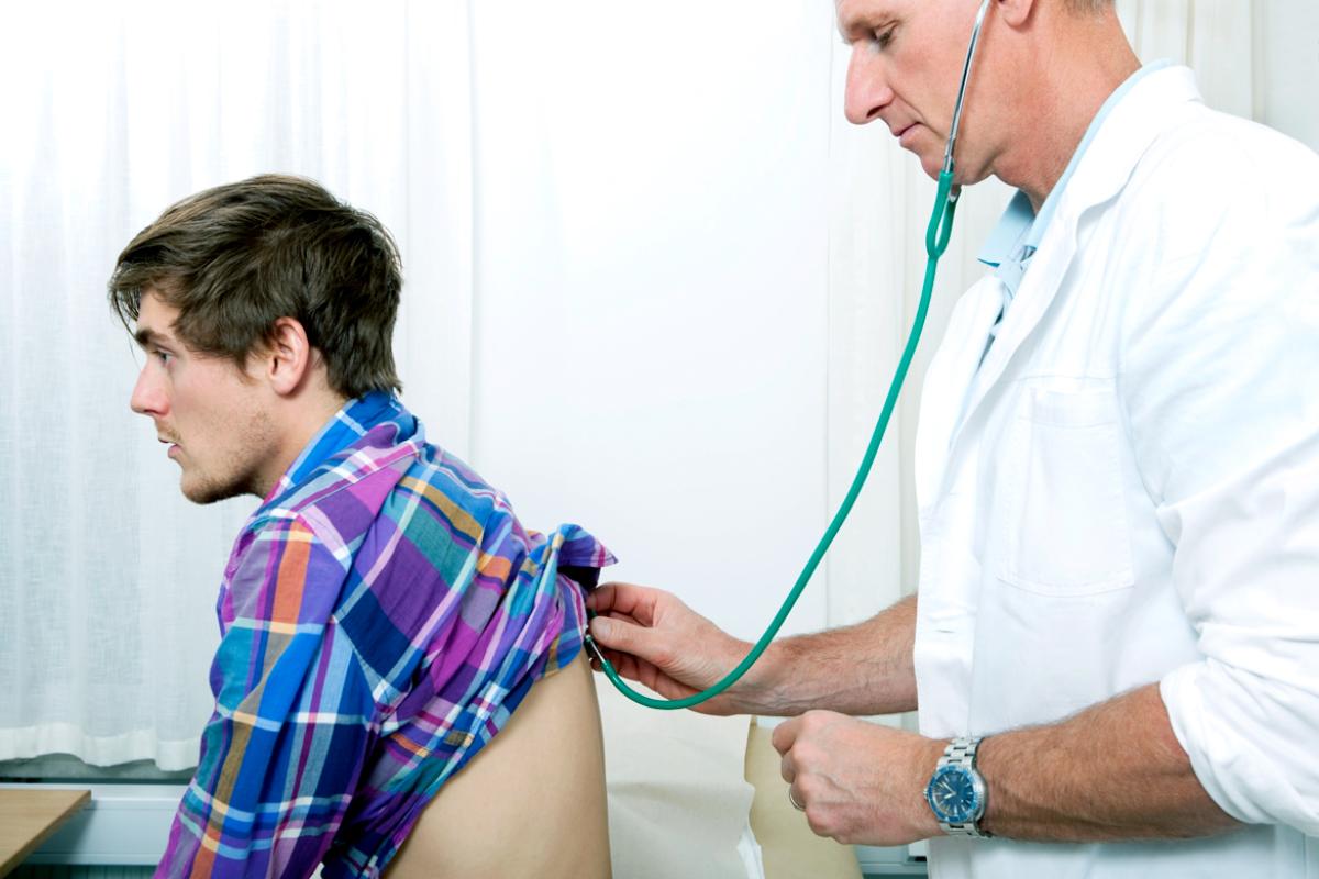Physician examines millenial patient.