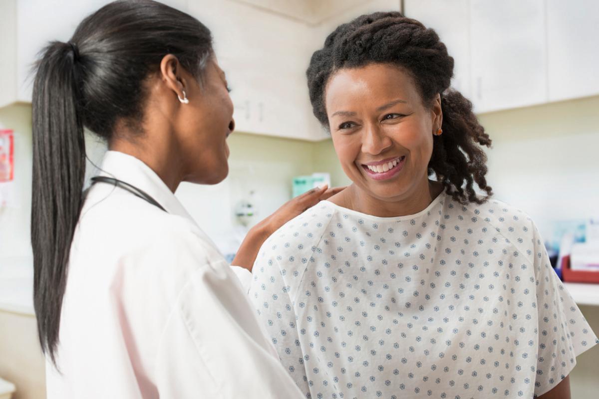 Physician with her hand on smiling patient's shoulder.