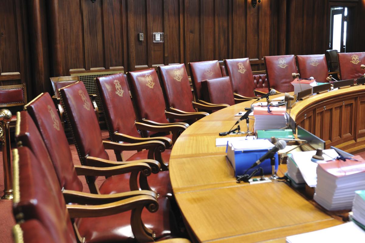 Empty chairs surrounding court hearing table. 