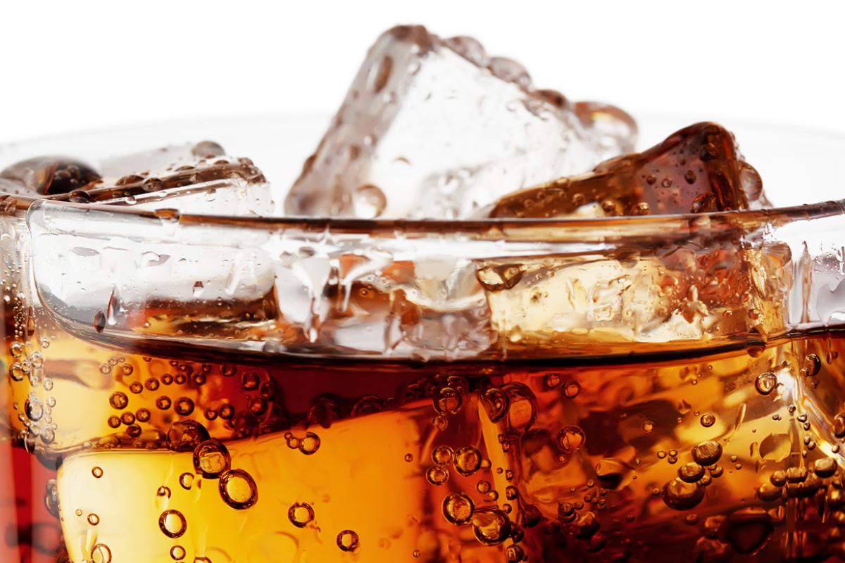 Glass filled with sugary beverage. 
