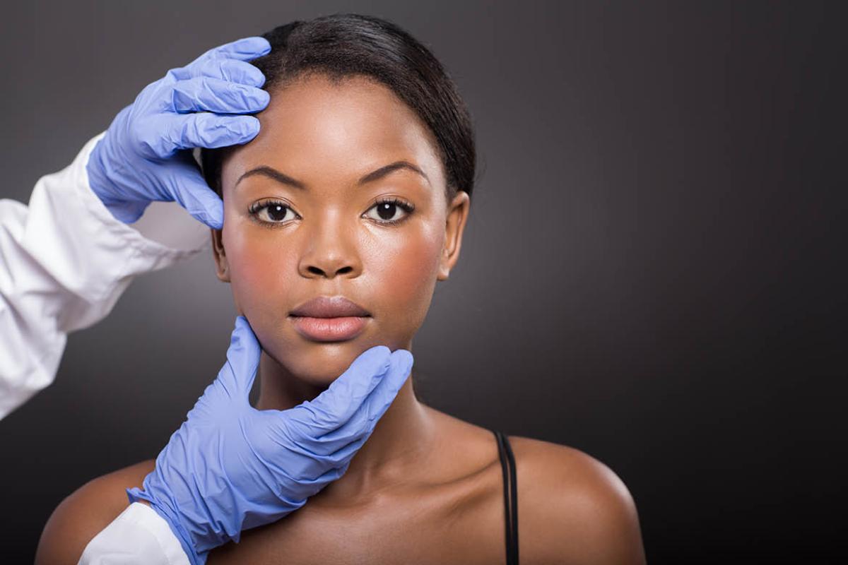 Physician studying the color of a woman's skin. 