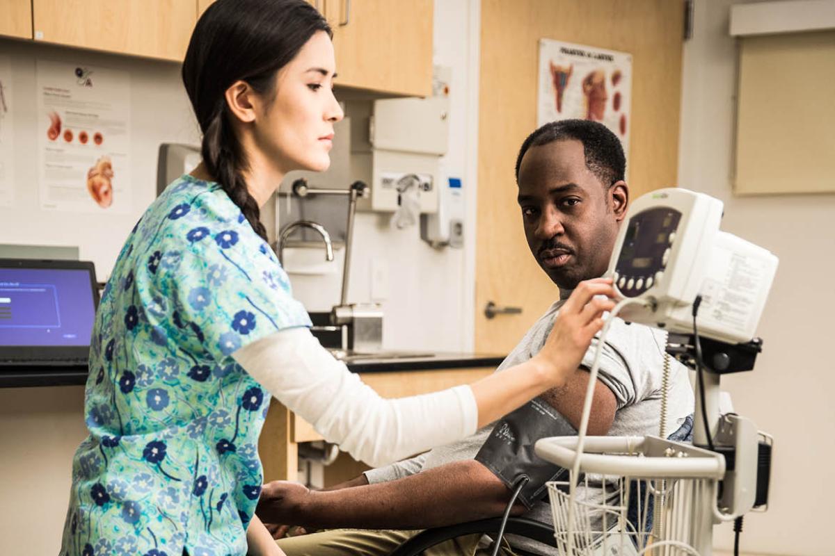 Medical technician taking patient's blood pressure.