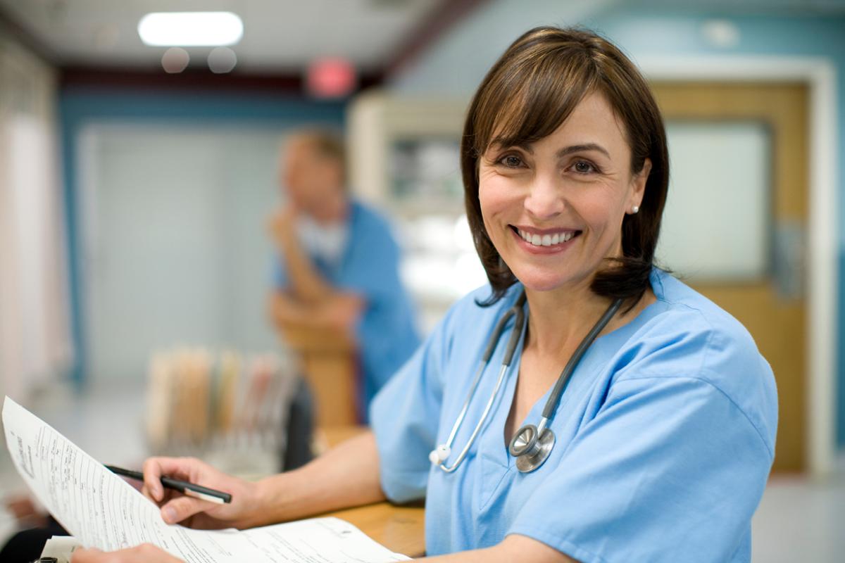 Smiling physician fills out survey. 