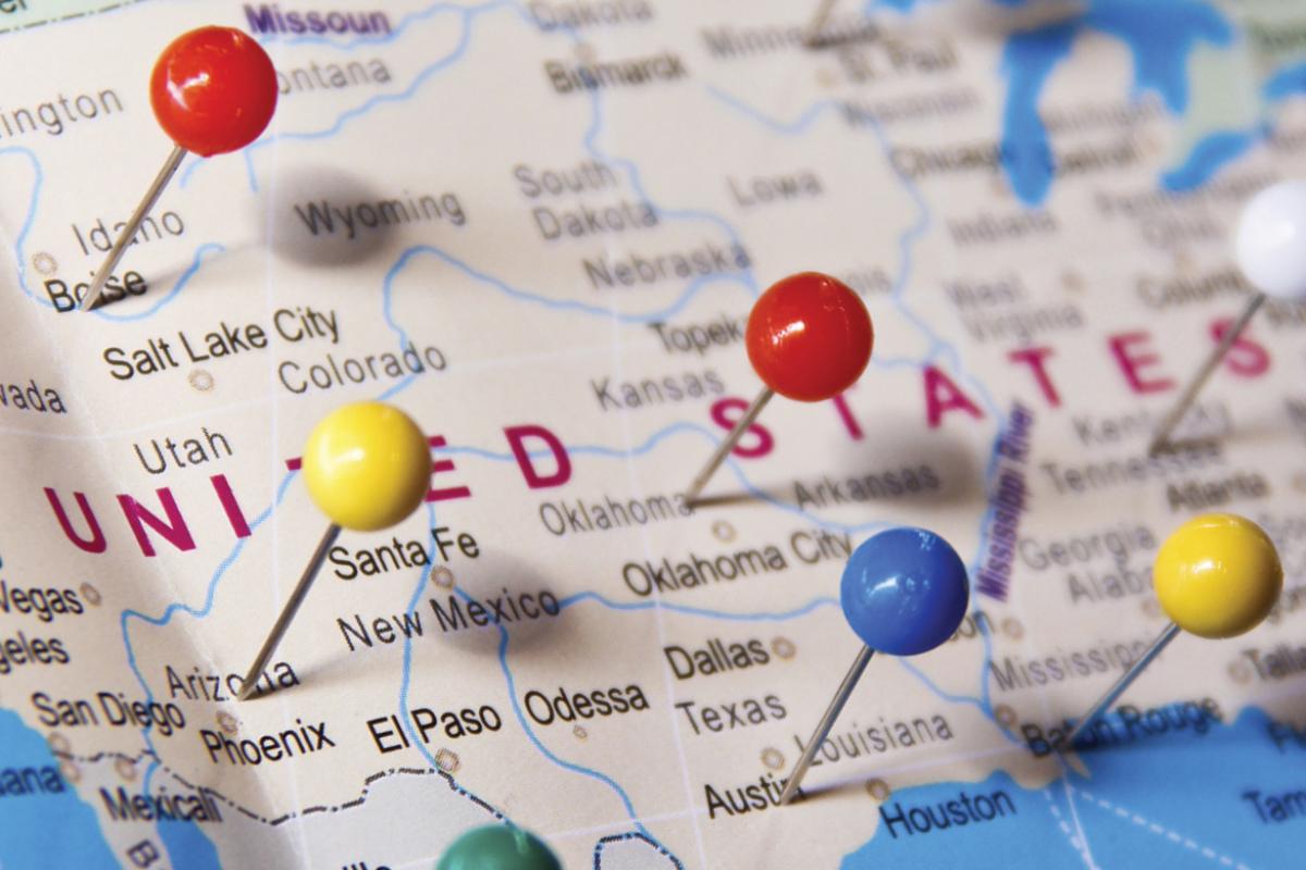 Close-up of US map with pins stuck in various locations. 
