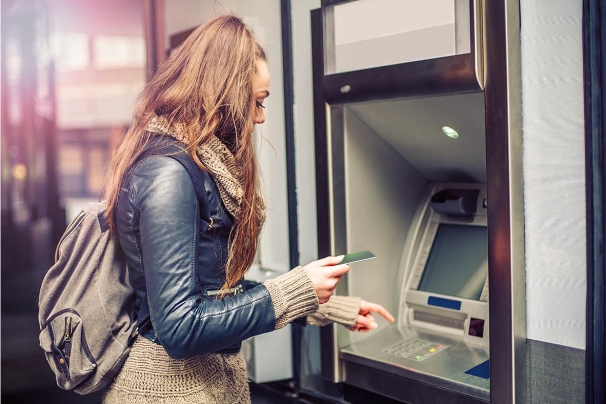 Medical student withdrawling money from an ATM.