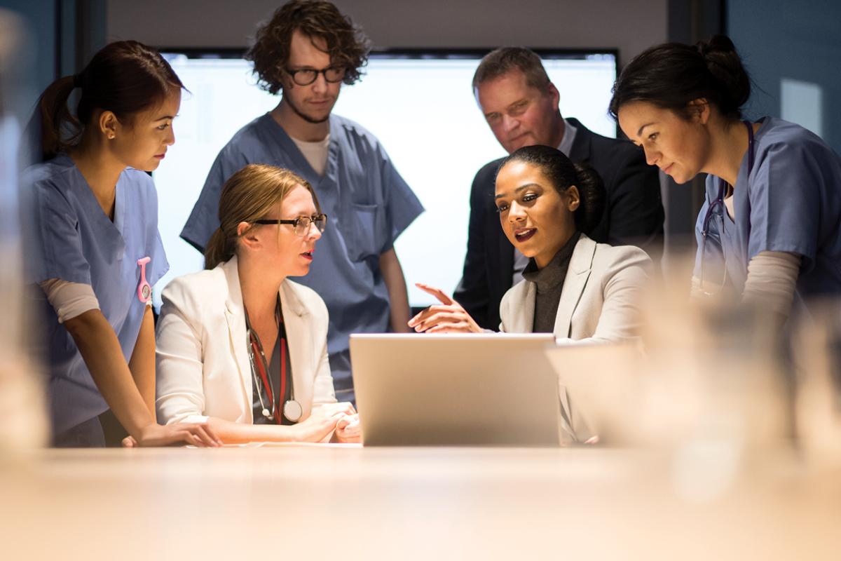 Medical professionals discussing what is on a computer screen as a group
