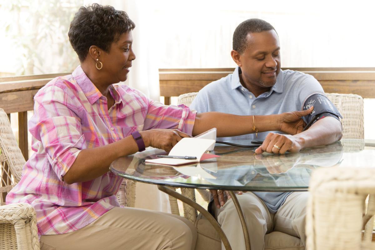 An African-American couple checking each other's blood pressure.
