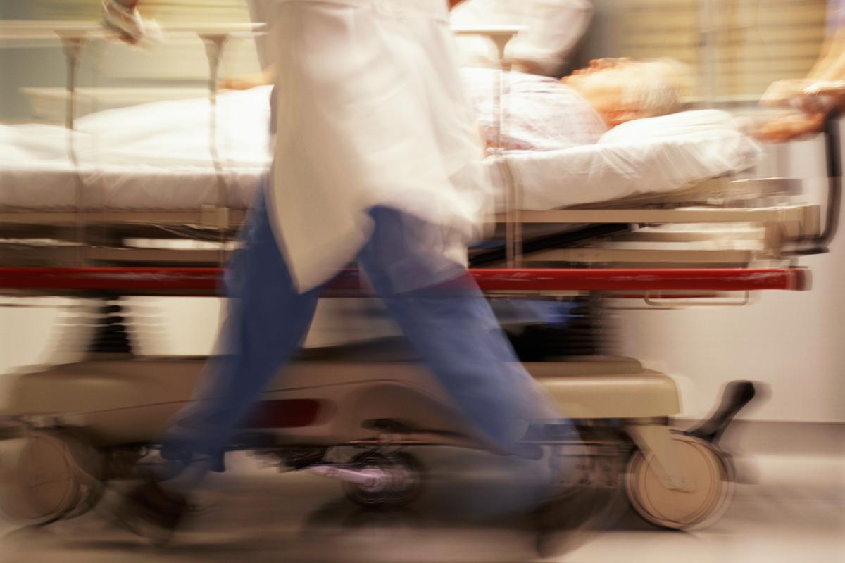 An action shot of doctors pushing a patient in a gurney.