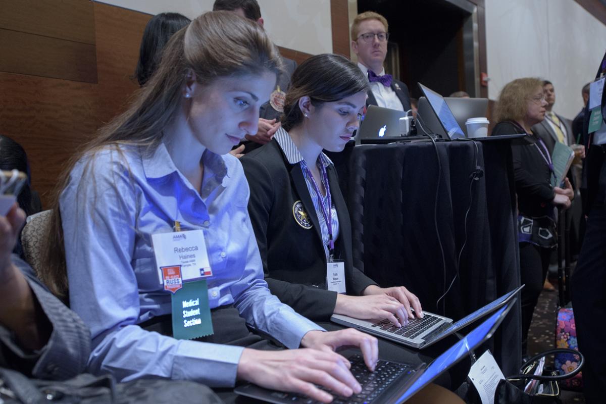 Student delegates Rebecca Haines and Faith Mason at AMA House of Delegates reference committee meeting.