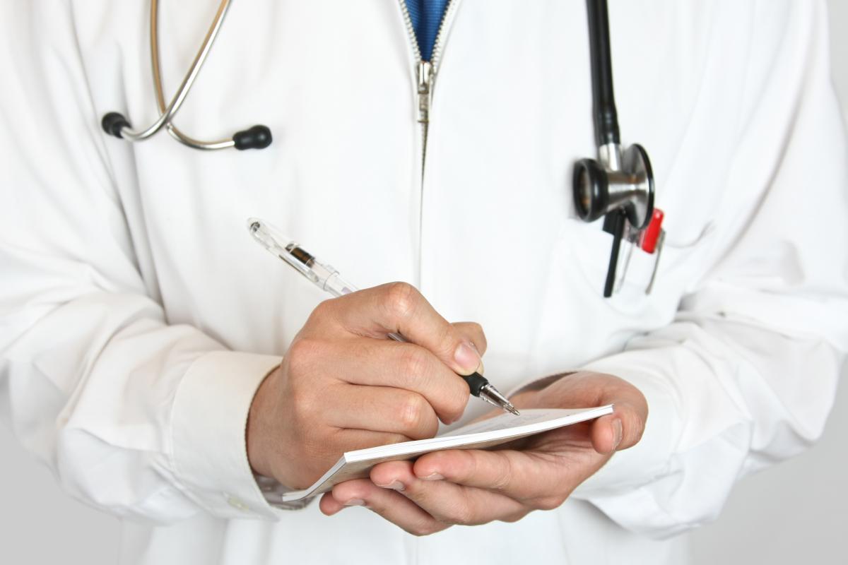 Physician writing on a prescription tablet