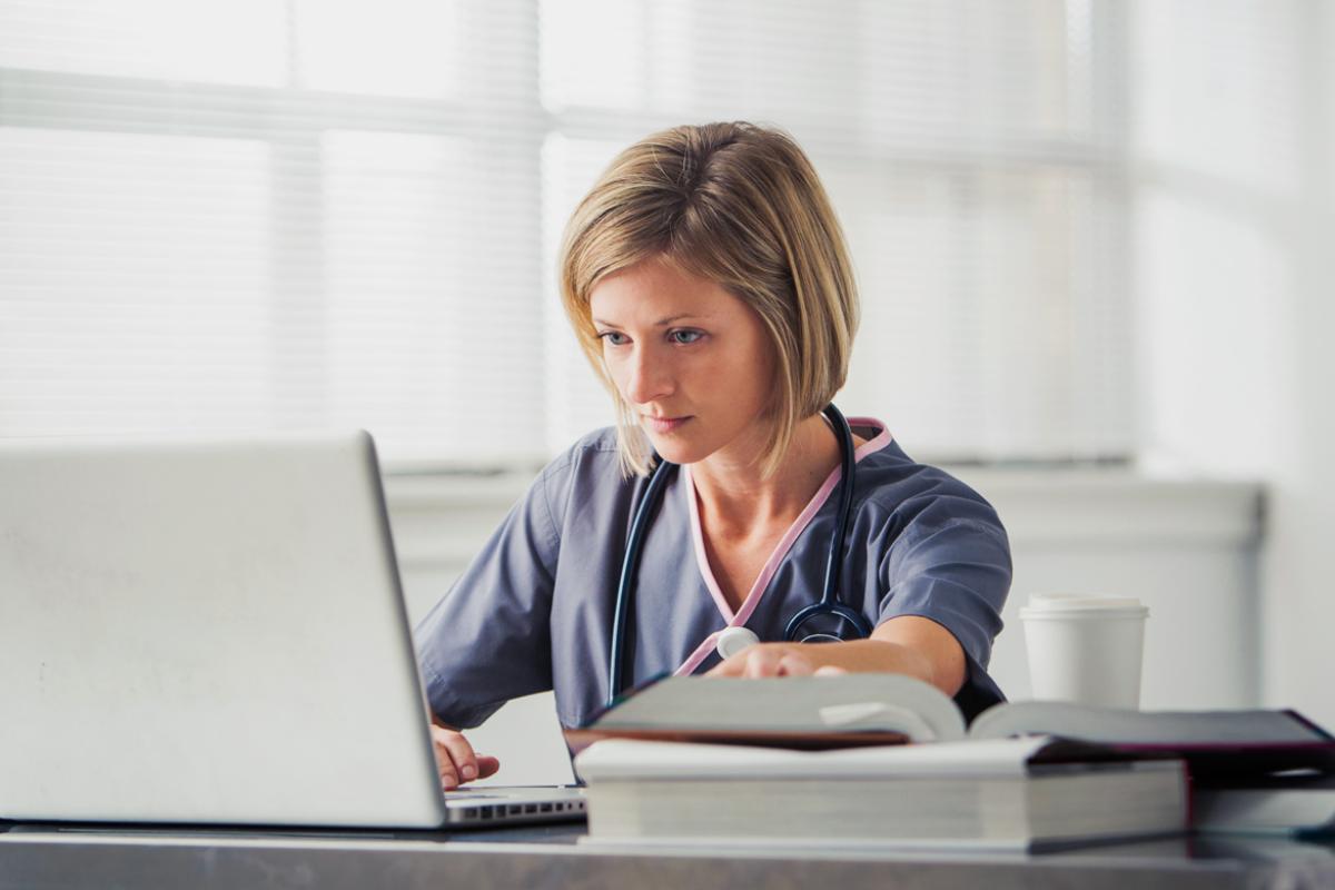 Medical professional reviews information on computer.