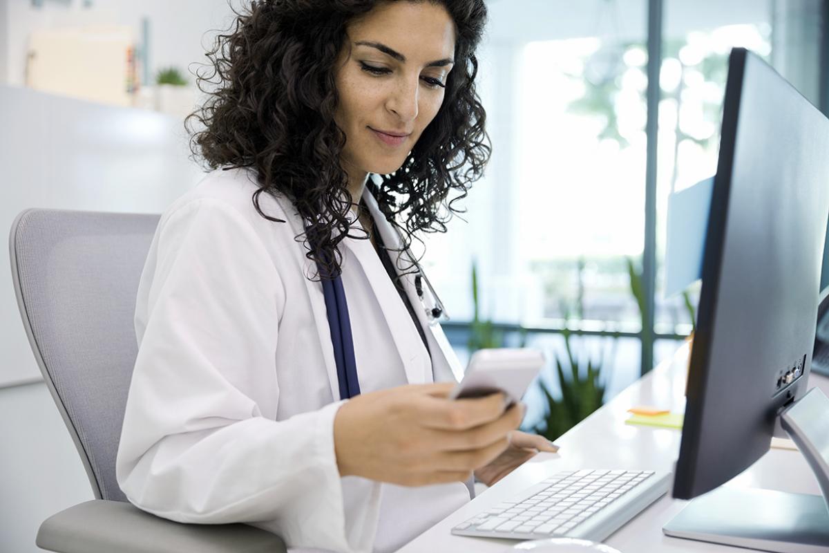 Medical professional reviews information on cell phone.